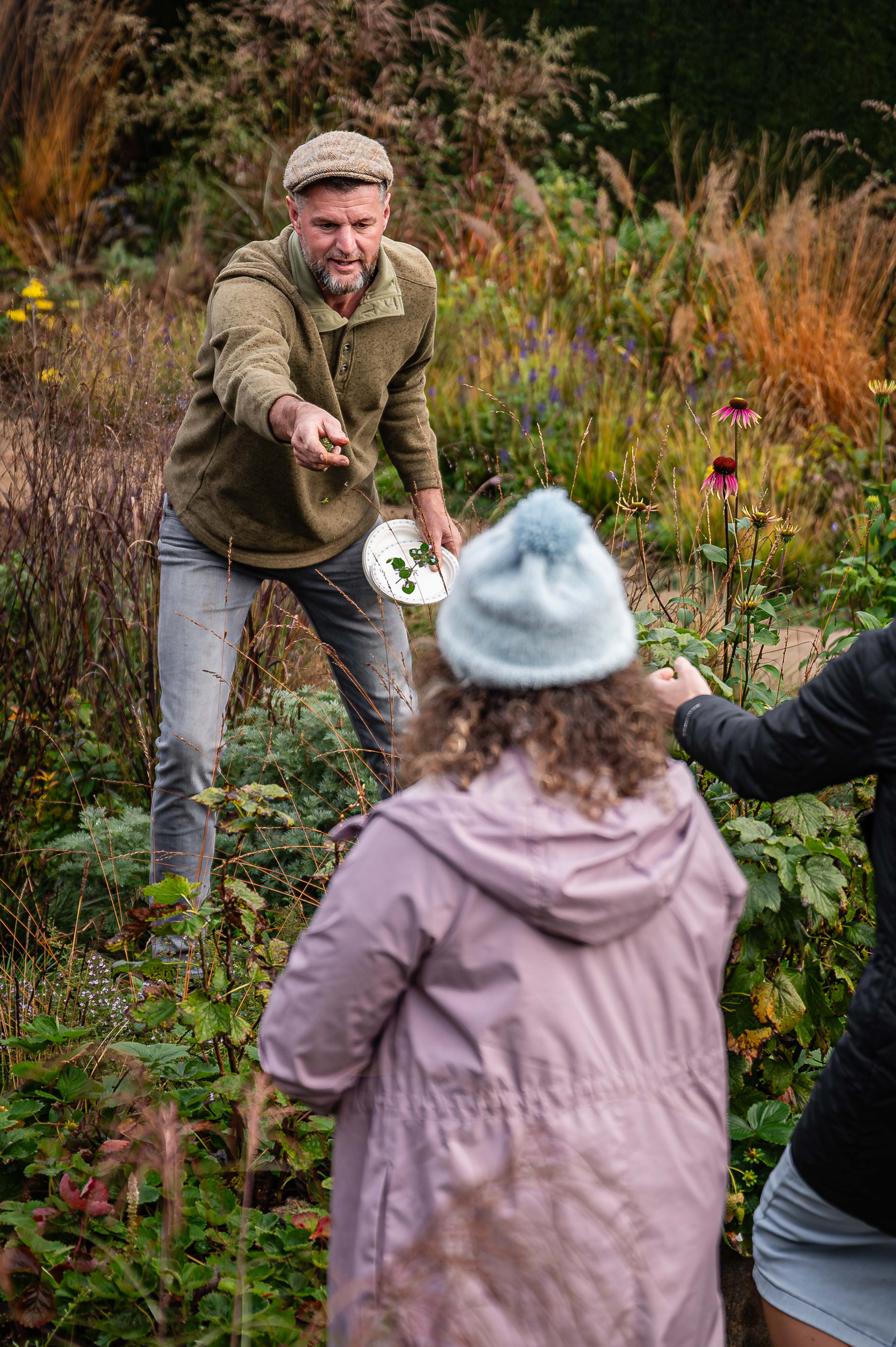 Jack holding out a flower to a student. 